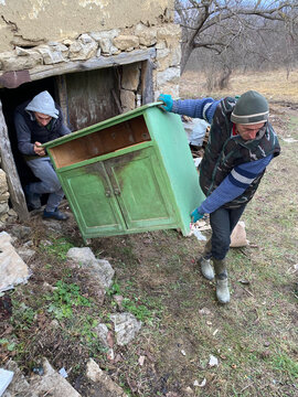 Workers carry out an antique cabinet. 