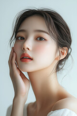 A charming Korean woman with smooth skin and natural hair gently touching her face in a minimalist white setting capturing the essence of beauty and elegance in a serene atmosphere