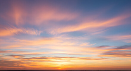 Dramatic sky with fast-moving wispy cirrus clouds illuminated by the setting sun