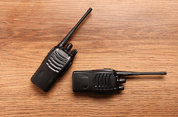 Walkie talkies on wooden table, top view
