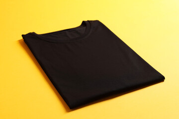 Blank black t-shirt on yellow background. Mockup for design