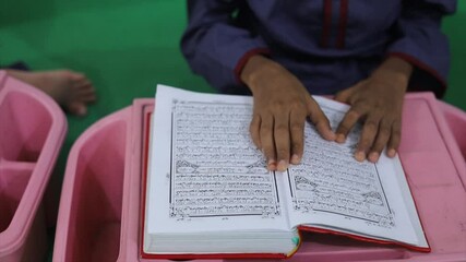 Person is reading a qur'an book with their hands