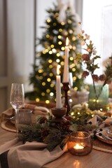 Christmas place setting with festive decor on wooden table in room