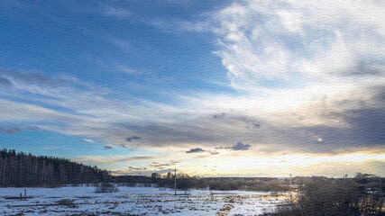 Snowy field with a blue sky and clouds