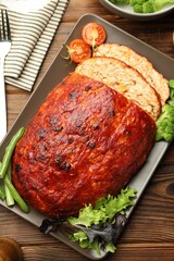 Delicious turkey meatloaf with vegetables served on wooden table, flat lay