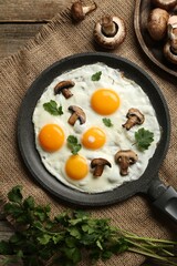 Tasty fried eggs with mushrooms and parsley served on wooden table, flat lay