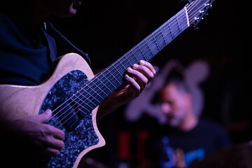 Naklejka premium Guitarist playing during a live jazz performance, focus on guitar.