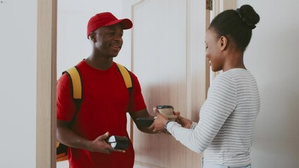 A man in a red cap and yellow backpack hands a package to a woman in a striped shirt at her apartment door. Both smile, showcasing a friendly delivery interaction.
