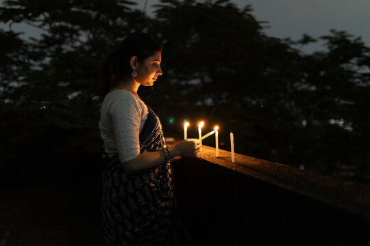 Indian woman lightening candle at outdoors