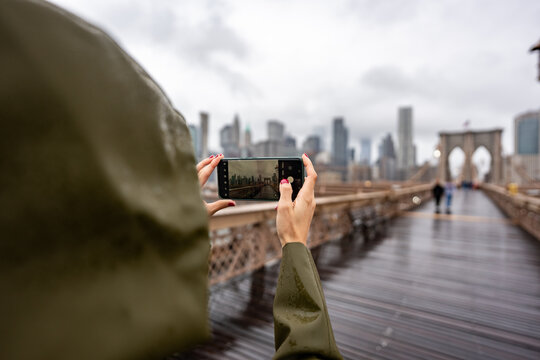 Woman capturing memories of iconic landmark during rainy day