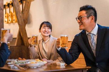 居酒屋・飲み屋で談笑する男女のサラリーマン
