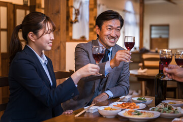 居酒屋で忘年会・新年会・飲み会・宴会をする仕事仲間・同僚・上司部下の男女
