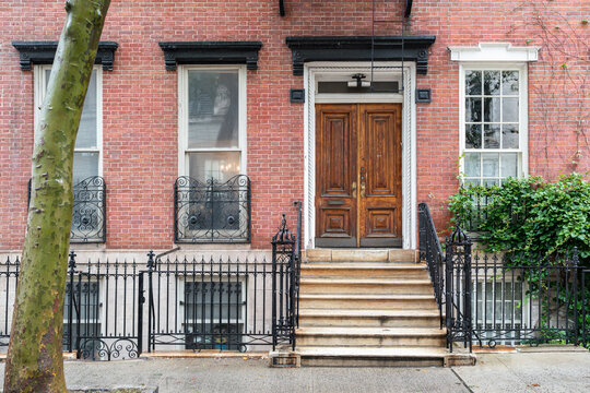 Elegant brownstone building facade with wrought iron fence
