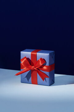 A beautifully wrapped gift box with colorful ribbon on a  blue b