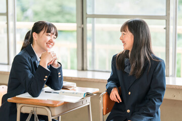 学校の教室で友達・クラスメイト・同級生と休憩時間に話す小学生・中学生・高校生

