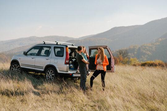 Family Enjoying Scenic Hillside View During a Road Trip Adventure