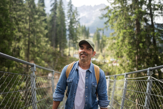 man on the suspension bridge of lake carezza in the dolomites