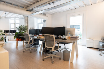 Coworking office interior with computers and chairs showing