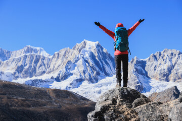 Backpacking woman hiking on high altitude mountain top