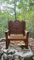 Ornate Wooden Throne in Lush Forest Setting.