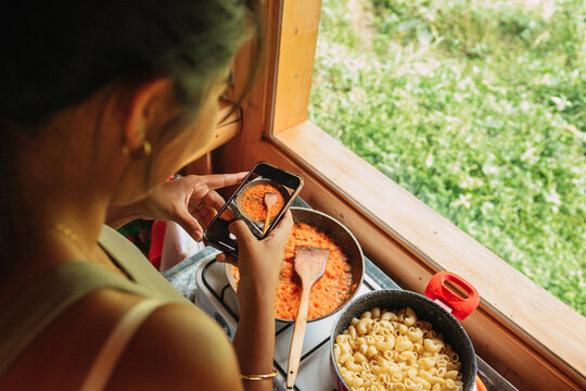 Woman taking photo of her food while cooking