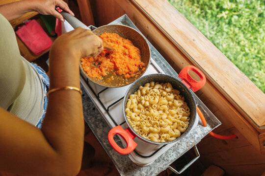 Woman cooking pasta with tomato sauce