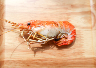 Single grilled shrimp on a wooden tray. Top view.