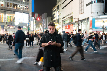 Man using phone on the street at night 