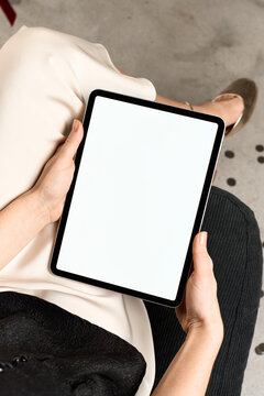 A woman uses a tablet with white screen at a party