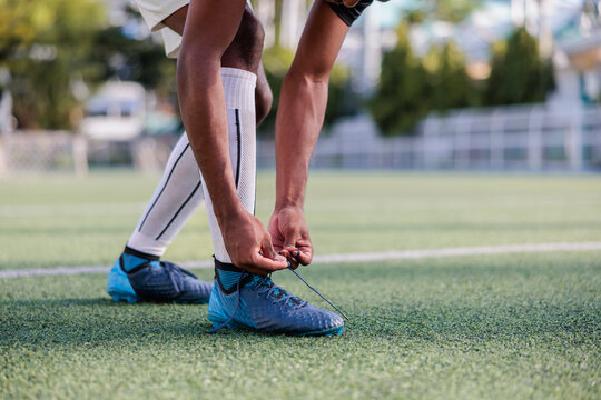 Male soccer player tying shoelace in sports ground
