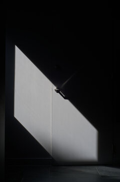 Light and shadow dance as a door calls from the dark