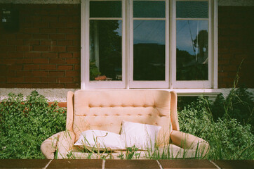 Charming couch non front porch nestled in overgrown garden