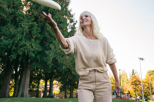Happy Seniors Playing Frisbee in a Park in Vancouver, British Columbia