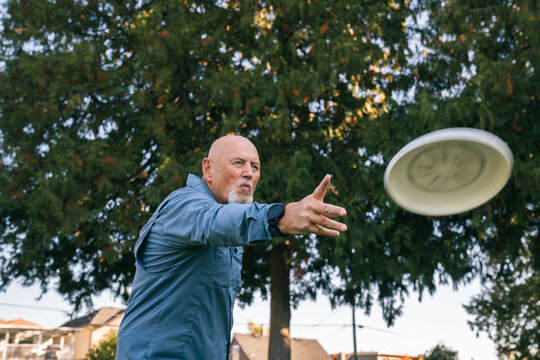 Happy Seniors Playing Frisbee in a Park in Vancouver, British Columbia