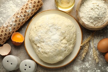 Fresh dough, ingredients and rolling pin on grey table, flat lay