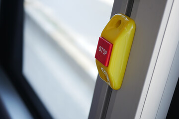 Public transport stop button inside a city bus during the day