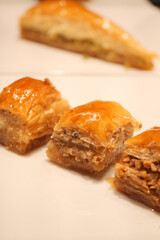 Delicious baklava dessert served on a white plate at a gathering