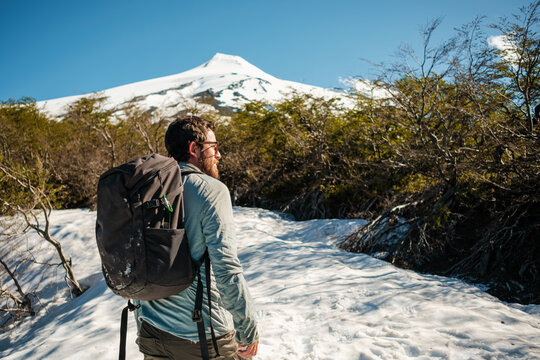 Hiker exploring snowy landscape with his backpack