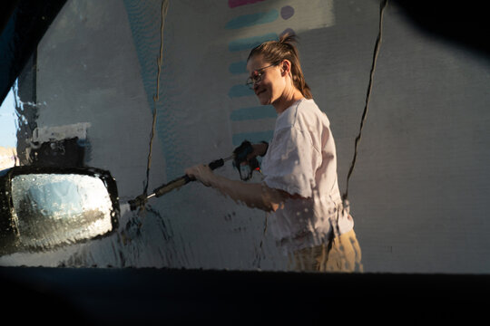 Distorted Reflection of Woman Washing Car