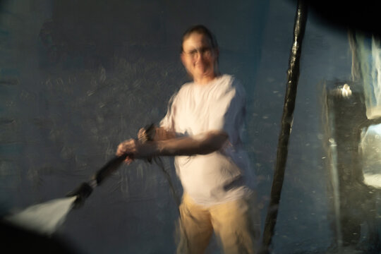Blurred View of Person Washing with Pressure Washer