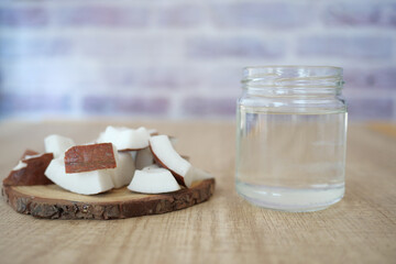 Fresh coconut pieces and coconut water on a wooden table