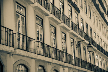 Sepia-toned image of historic building facades with balconies in Lisbon.