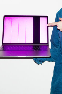 Person holding a laptop with broken screen in office workplace