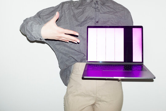 Person holding a laptop with broken screen in office workplace