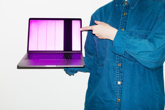 Person holding a laptop with broken screen in office workplace