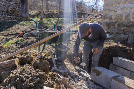 Block mason fills a concrete finishing tool.