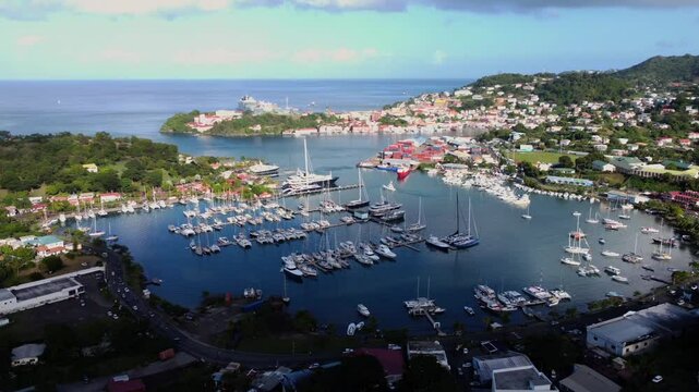 Aerial pan of half shadow seaside town with harbor yachts