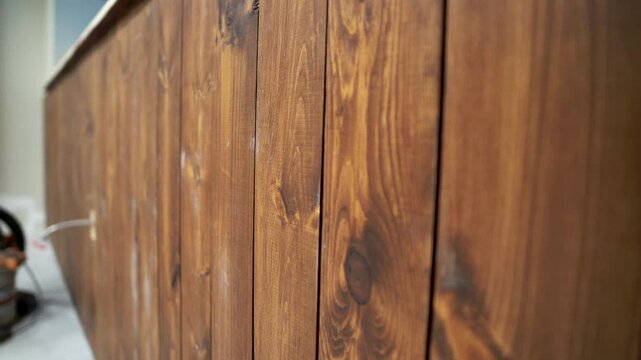 Stained wood panels installed along a wall at a construction site in 4K