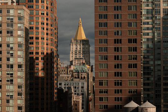 Golden spire amidst modern and historic New York buildings 