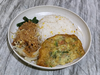 Pecel Rice. A traditional Javanese rice dish consisting of white rice with vegetables, peanut sauce, eggs.